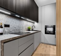 Küche in einer 2-Zimmer-Wohnung mit Holzboden und stilvollen Schränken.