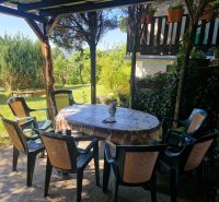 Garten mit Terrasse bei der Hütte in Žilina, Plastikstühle um den Tisch.