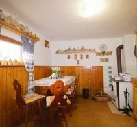 Innenraum einer Hütte mit rustikalen Möbeln und Dekorationen, Boden mit Holzdekor.