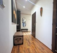 Der Flur einer 3-Zimmer-Wohnung mit einem Boden in Holzoptik und Wanddekorationen.