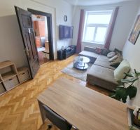 Das Wohnzimmer in der 3-Zimmer-Wohnung verfügt über eine bequeme Sitzgarnitur und einen Boden mit Holzdekor.