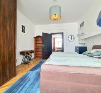 Schlafzimmer in einer 3-Zimmer-Wohnung mit Holzboden, Doppelbett und Möbeln.