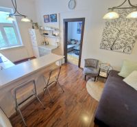 Küche in einer 3-Zimmer-Wohnung mit Bartresen und Holzboden.