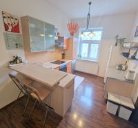 Küche in einer 3-Zimmer-Wohnung mit Bartresen, Regalen und Bodenbelag in Holzoptik.