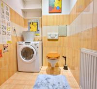 Badezimmer mit Waschmaschine, Toilette und Kunstbild in einer 3-Zimmer-Wohnung.