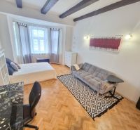 Teilweise möblierte 3-Zimmer-Wohnung mit Sofa, Tisch und Boden in Holzoptik.