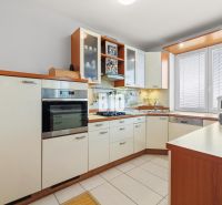 Küche in einer 4-Zimmer-Wohnung mit weißen Schränken und eingebauten Geräten.