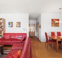 Rote Ledersofas und ein Esstisch in einer 4-Zimmer-Wohnung mit Holzboden.