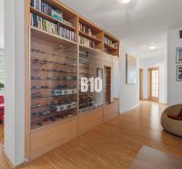 Flur in einer 4-Zimmer-Wohnung mit einer Vitrine für Automodelle und einem Boden mit Holzdekor.