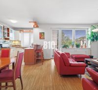 Wohnzimmer in einer 4-Zimmer-Wohnung mit rotem Sofa und Holzboden.