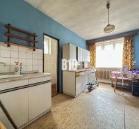Küche in einem Einfamilienhaus mit Möbeln und Boden in Holzoptik.
