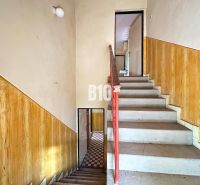 Treppe mit Geländer und Wänden mit Holzdekor in einem Einfamilienhaus.