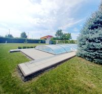 Ein Einfamilienhaus in Nové Zámky mit einem Pool im Garten und einer Kiefer.