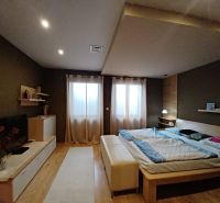Schlafzimmer mit Bett, Holzboden und komfortabler Einrichtung in einem Einfamilienhaus.