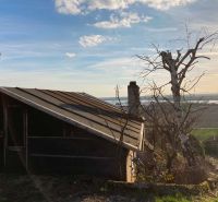 Eine Hütte in den Bergen mit Blick auf die Landschaft und Bäumen in der Umgebung.