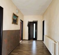 Ein Flur in einem Einfamilienhaus mit einem Holzboden und einem Bild an der Wand.