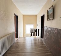 Ein Flur in einem Einfamilienhaus mit einem Boden in Holzoptik, dekorativen Wänden und einem Heizkörper.