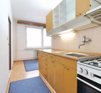 Küche in einer 2-Zimmer-Wohnung mit Küchenzeile, Herd und großem Fenster.