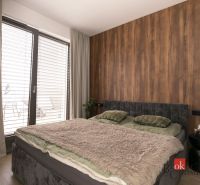 Doppelbett mit weicher Decke in einer 2-Zimmer-Wohnung mit Holzboden.