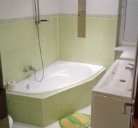 Badezimmer mit Eckbadewanne und grünen Fliesen in einer 3-Zimmer-Wohnung.
