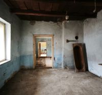 Ein Zimmer in einem Einfamilienhaus mit blauen Wänden, einer alten Nähmaschine und einem hölzernen Trog.