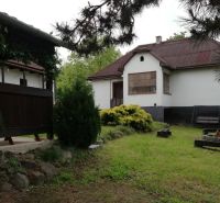 Ein Einfamilienhaus, umgeben von einem Garten, einer Terrasse und einer Feuerstelle, schafft eine angenehme Wohnumgebung.