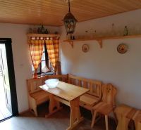 Das ländliche Interieur bietet eine Holzbank und einen Tisch, die Möbel vervollständigen die Atmosphäre eines Familienhauses.