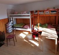Etagenbetten, Kaminofen und Möbel im Zimmer eines Einfamilienhauses.