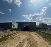In Hniezdne ein Gebäude mit einer Halle für eine Pferdeausstellung an einem sonnigen Tag.