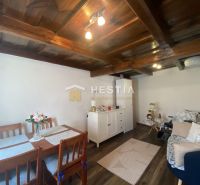 Wohnzimmer in einem Einfamilienhaus mit Möbeln und Boden in Holzoptik.