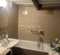 Badezimmer mit Badewanne, Waschbecken und Spiegel mit Dekoration in einem Einfamilienhaus.