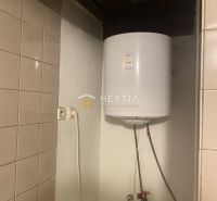 Boiler in einem Einfamilienhaus mit Keramikfliesen an der Wand.