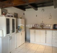 Küche in einem Einfamilienhaus mit Holzbalken und weißen Schränken.