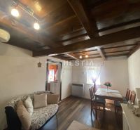Wohnzimmer in einem Einfamilienhaus mit Holzdecke und Boden in Holzoptik.