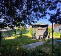Ein Garten bei einem Einfamilienhaus in Borský Mikuláš mit einem Holzbau und Bäumen.