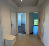 Der Flur in der 3-Zimmer-Wohnung mit Keramikfliesen und drei weißen Türen.