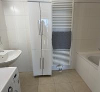 Badezimmer in einer 3-Zimmer-Wohnung, mit weißen Möbeln und Waschmaschine.