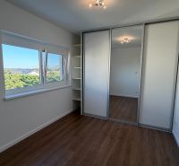 Ein Zimmer in einer 3-Zimmer-Wohnung mit einem Boden in Holzoptik und einem Einbauschrank.