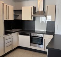 Küche in einer 3-Zimmer-Wohnung, mit passender schwarz-weißer Küchenzeile und Geräten.