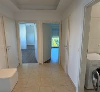 In einem 3-Zimmer-Wohnung mit Holzboden und einer Waschmaschine im Badezimmer.