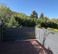 Balkon einer 3-Zimmer-Wohnung in Wolfsthal mit Blick ins Grüne und Satellitenschüssel.