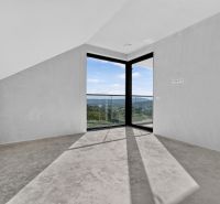 Ein geräumiges Zimmer in einer Wohnung mit 5 oder mehr Zimmern mit großen Fenstern und Betonboden.
