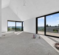 Ein geräumiges Zimmer in einer Wohnung mit 5 oder mehr Zimmern mit großen Fenstern und Betonboden.