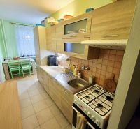 Küche in einer 4-Zimmer-Wohnung mit Holzelementen und Essecke.