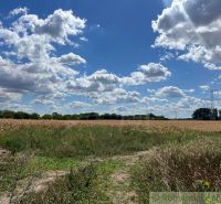 Landwirtschaftliche und forstwirtschaftliche Flächen in Bernolákovo mit blauem Himmel und Wolken, Feldern und Bäumen.