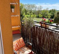 Ein Balkon in einer 3-Zimmer-Wohnung mit einem bequemen Sessel und Blick ins Grüne in Veľký Lapáš.