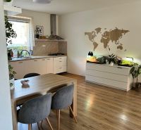 Küche in einer 3-Zimmer-Wohnung mit Holzboden, Tisch und Pflanzen.