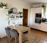 Küche in einer 3-Zimmer-Wohnung mit Wandregalen und einem Boden in Holzoptik.