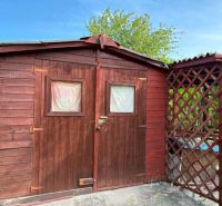 Holzgartenhaus mit überdachtem Unterstand in den Gärten von Komárno.