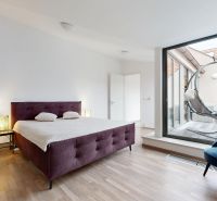 Helles Schlafzimmer in einer 4-Zimmer-Wohnung mit Bett und Terrasse, Boden mit Holzdekor.